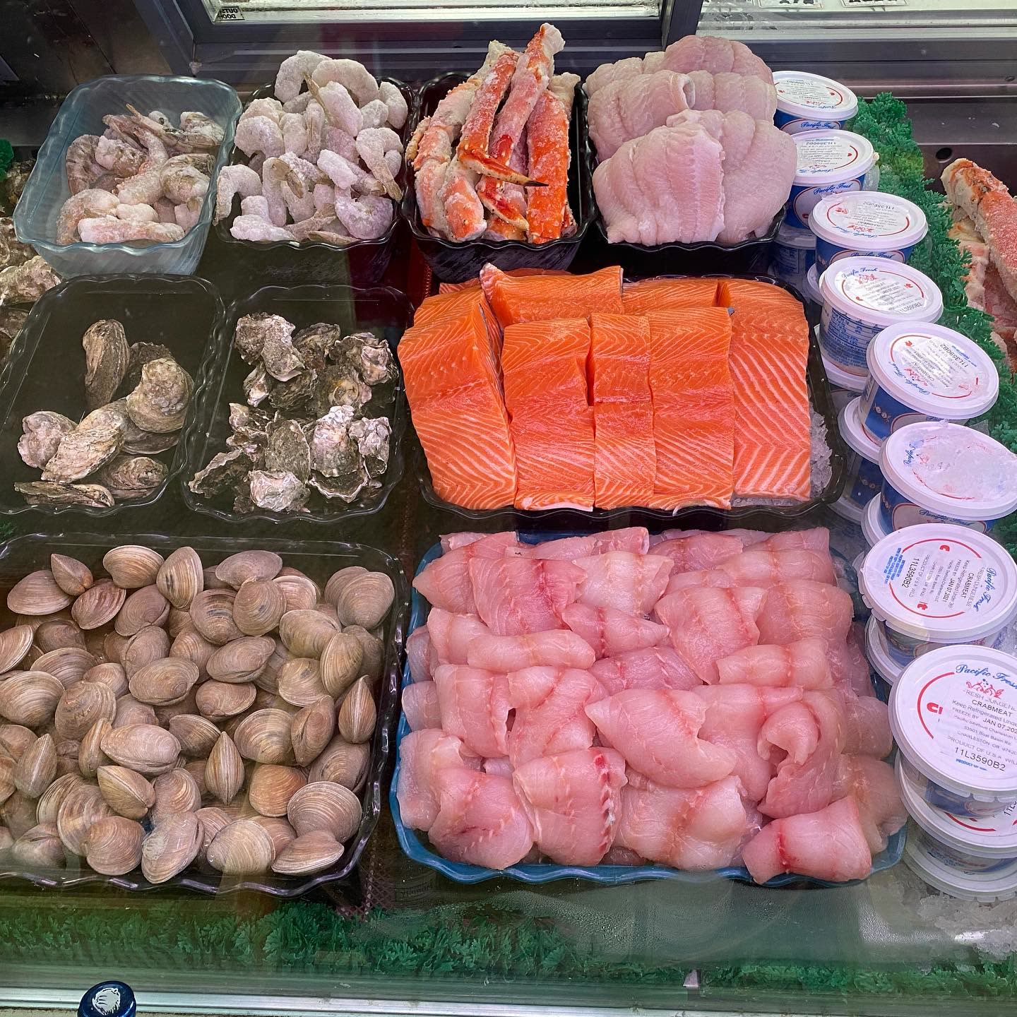 The seafood case: salmon fillets, clams, oysters, prawns, crab legs and fresh crabmeat on ice